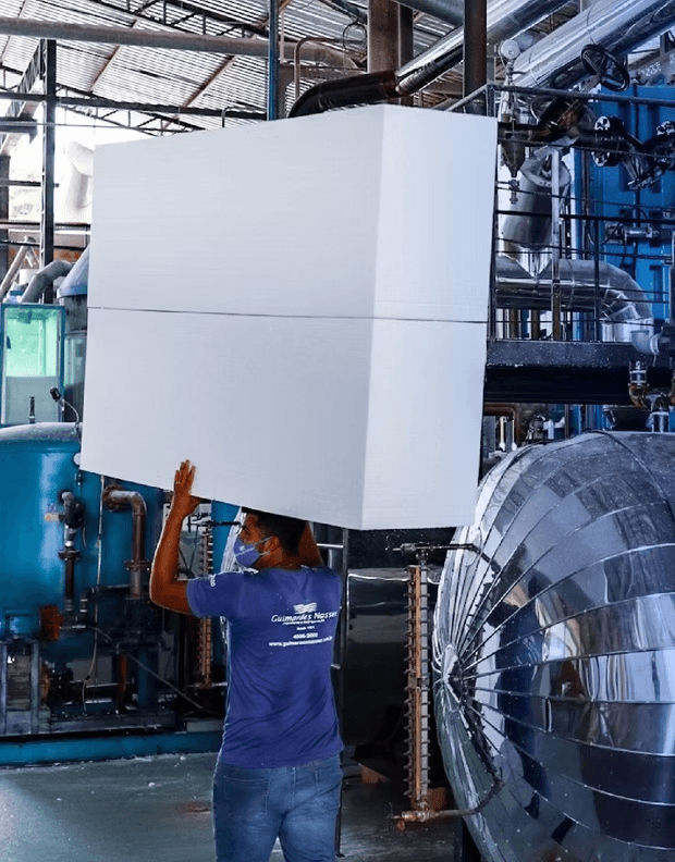 Operário instalando bloco de EPS em linha de produção industrial
